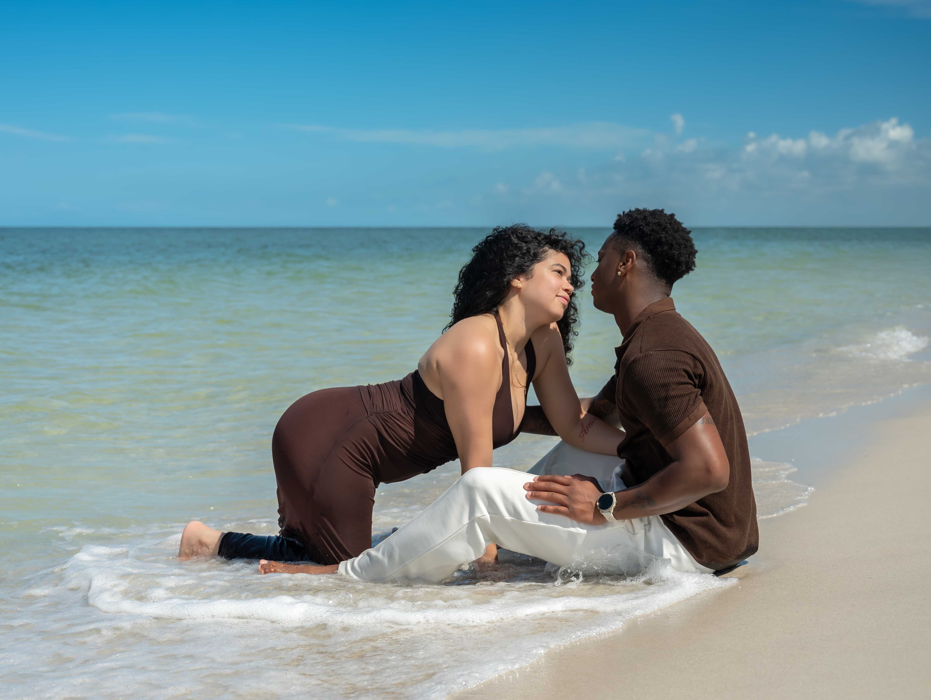 Couple sitting together in the shallow waves