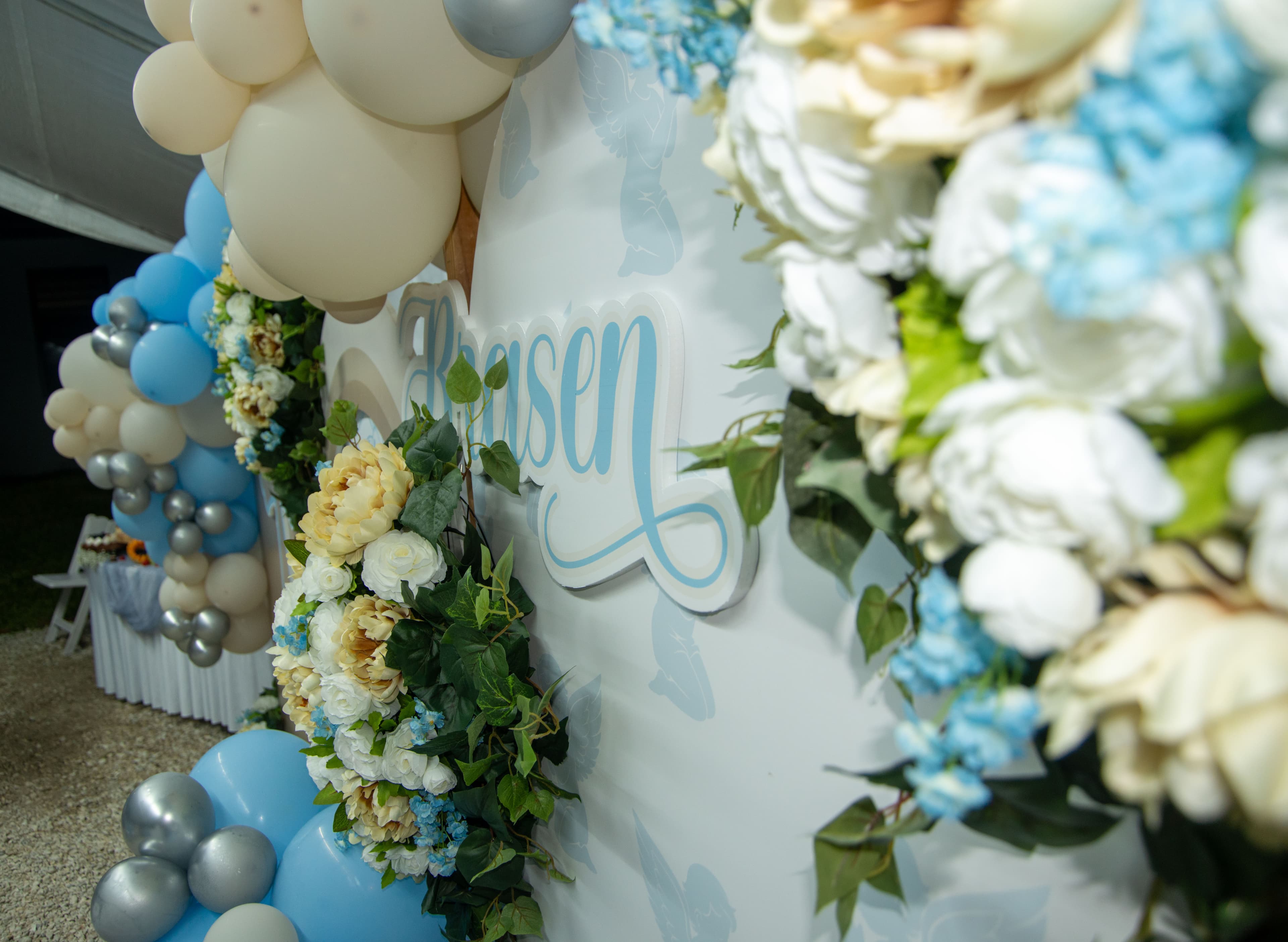 Floral name backdrop detail at a christening celebration