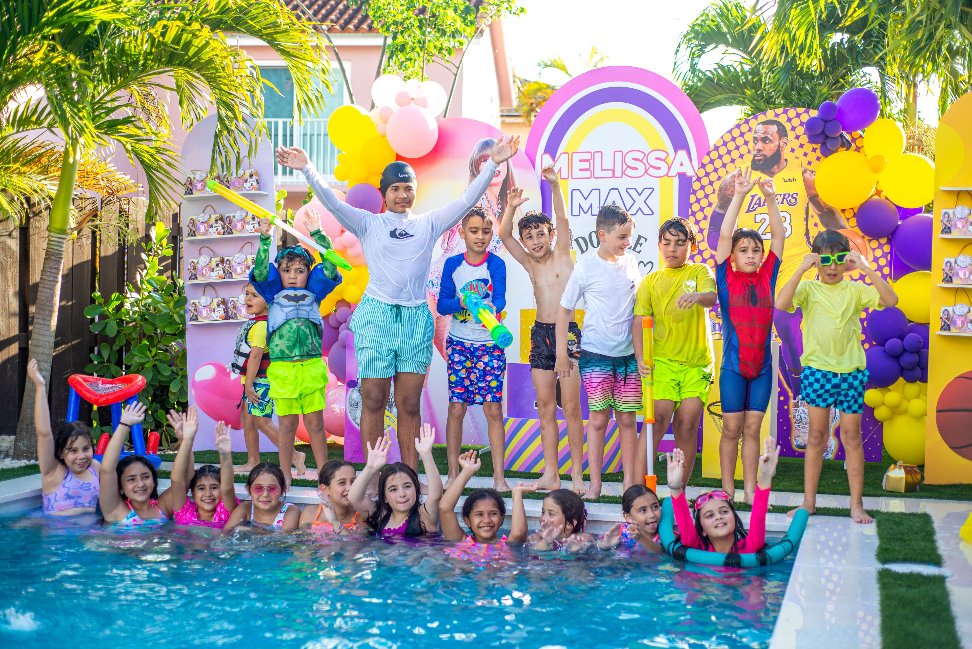 Kids jumping and posing poolside at a birthday party