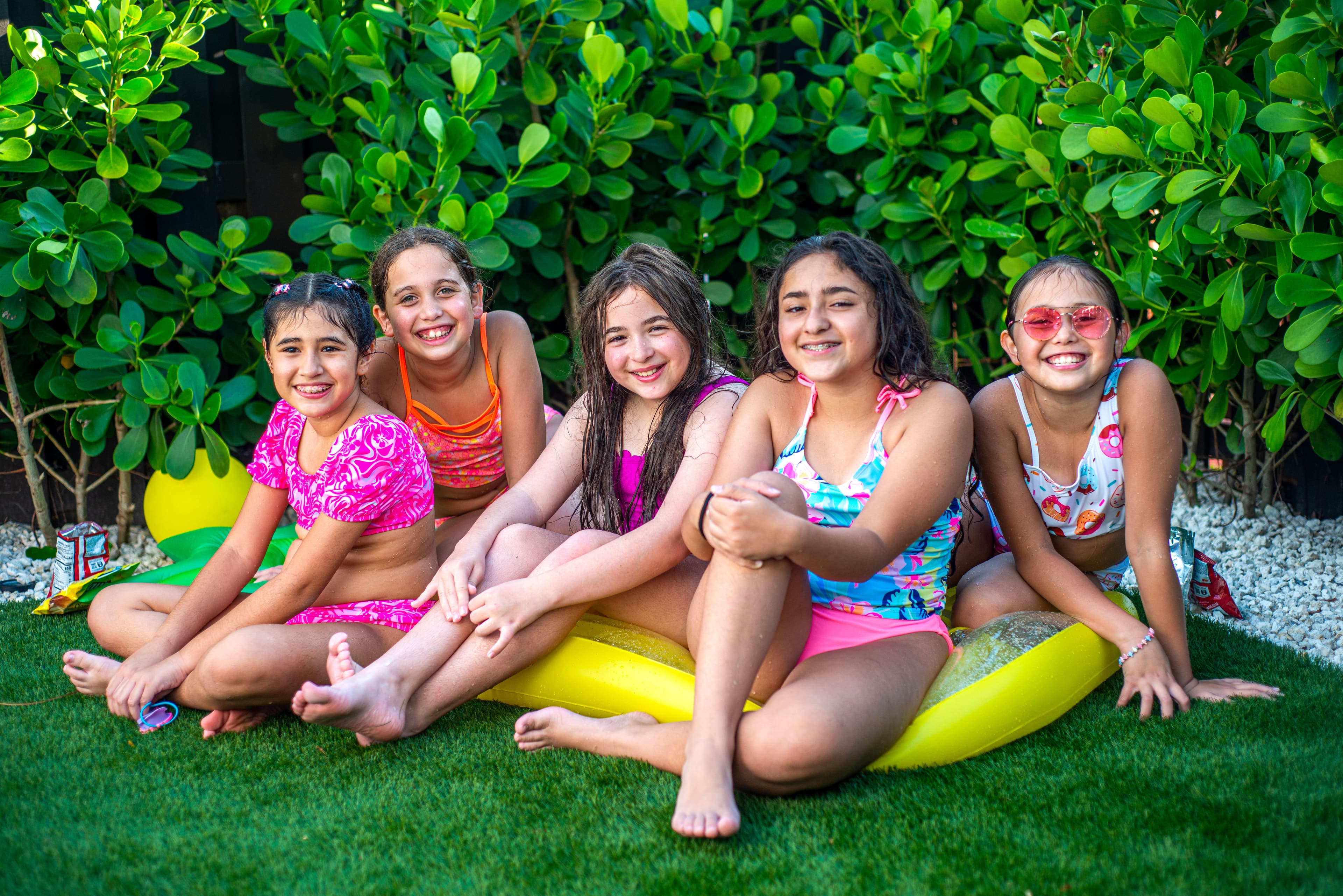 Friends smiling together at a poolside birthday celebration