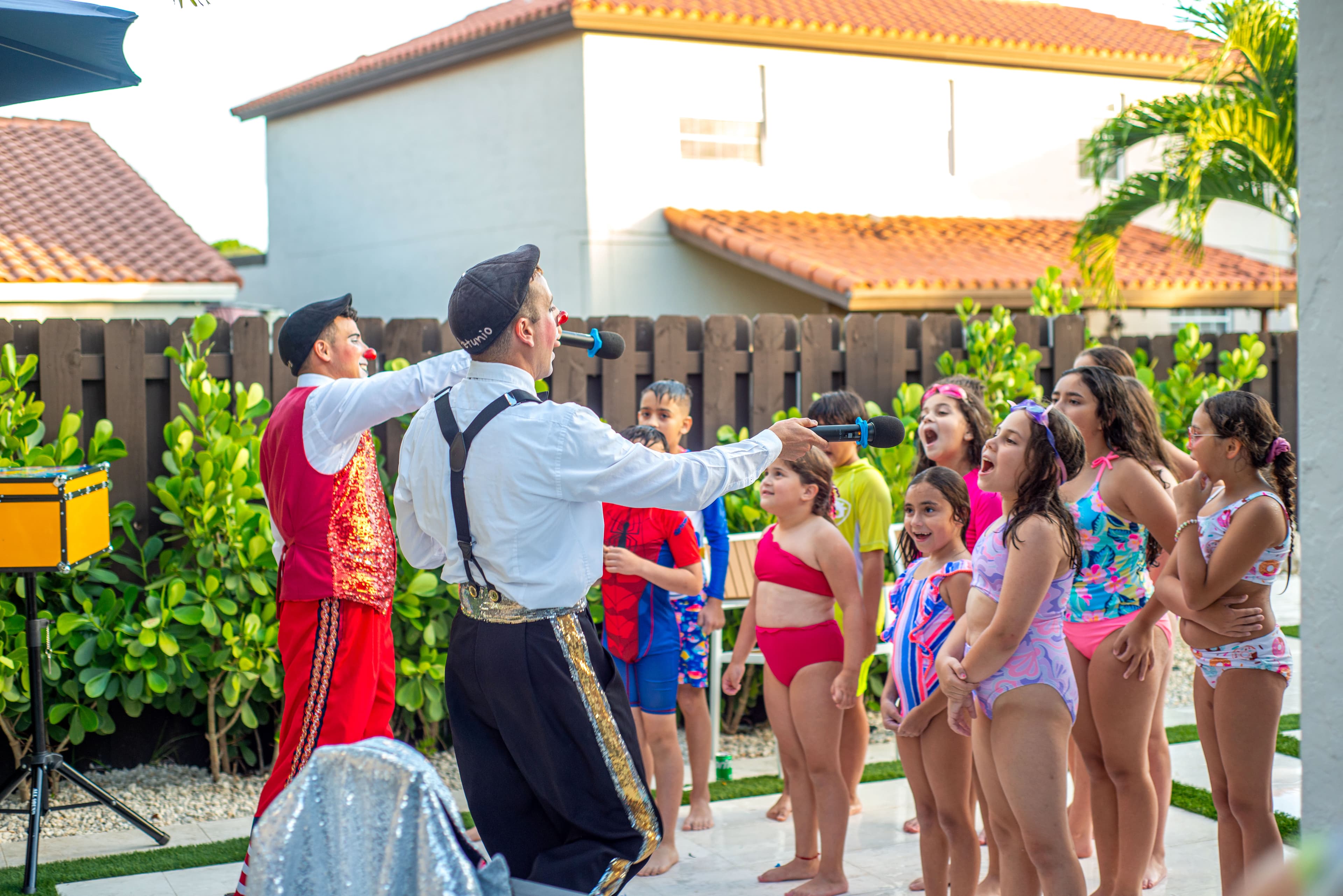 Clown entertainer engaging kids in a birthday party sing-along
