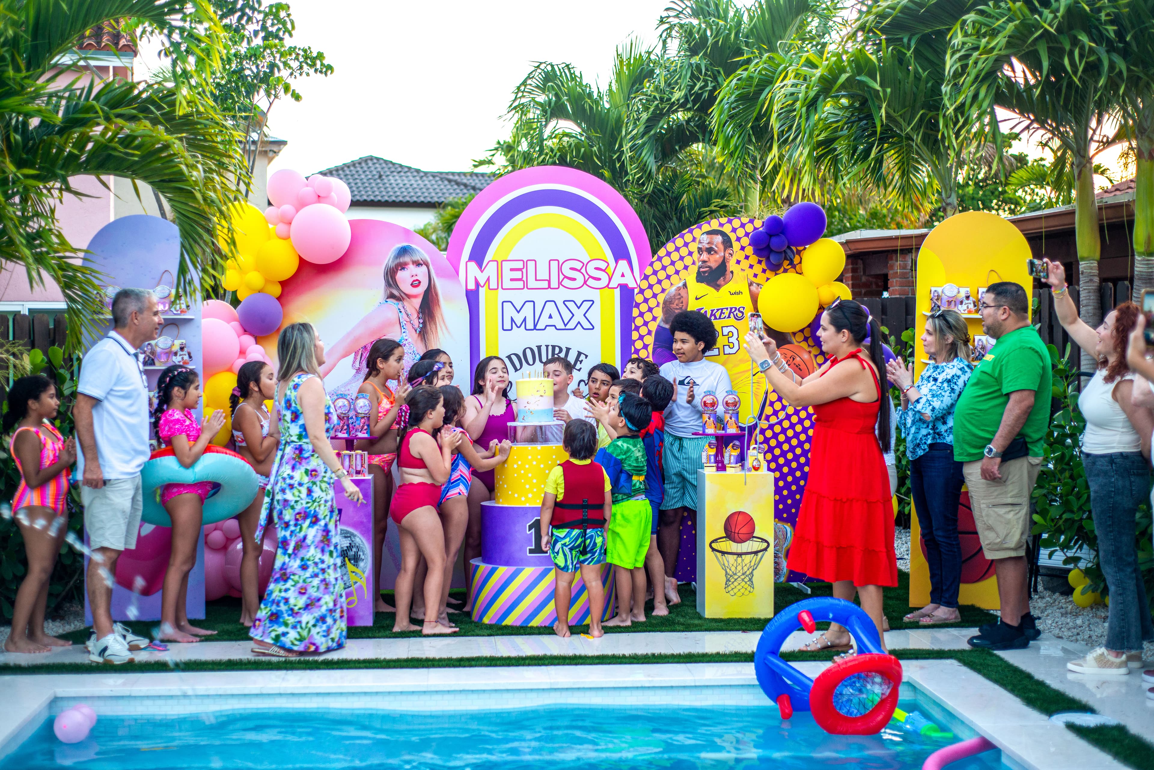 Guests celebrating around the cake at a poolside birthday party