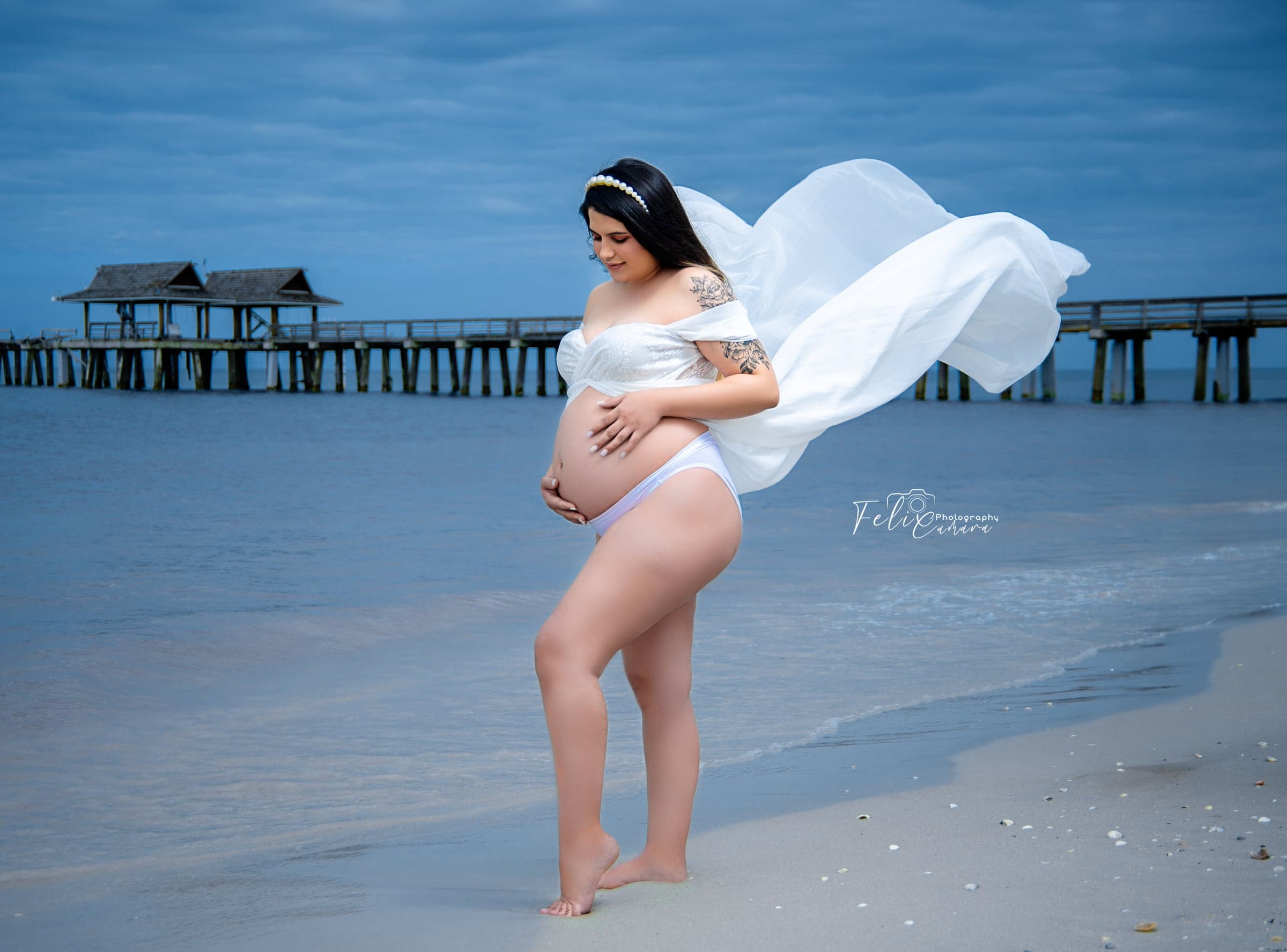Maternity portrait at Naples pier, flowing fabric