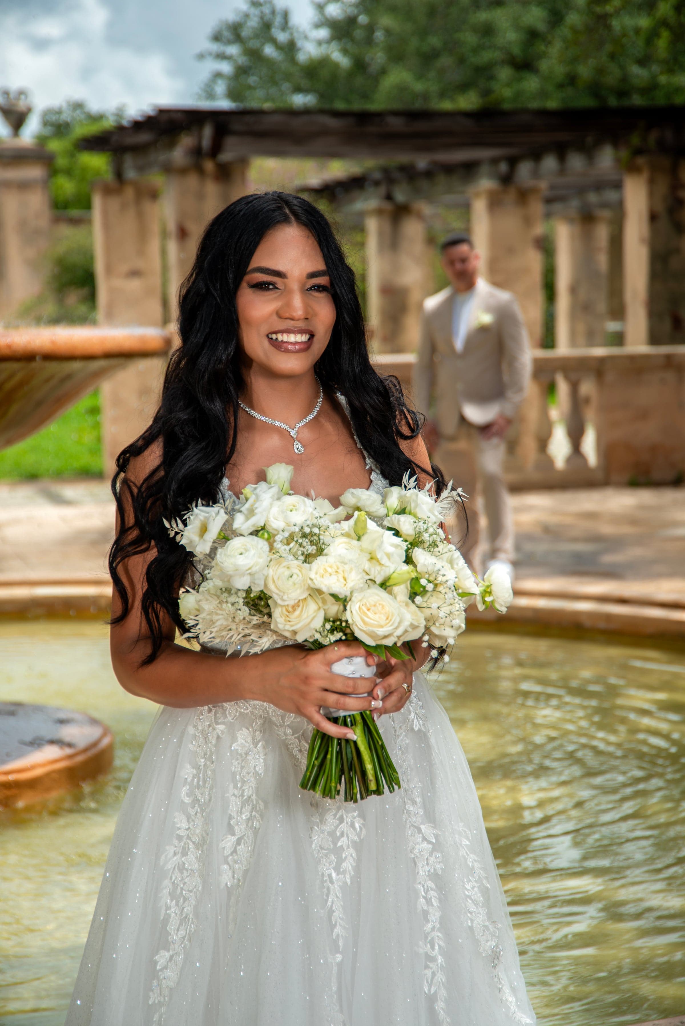 Bride portrait with bouquet, outdoor fountain venue