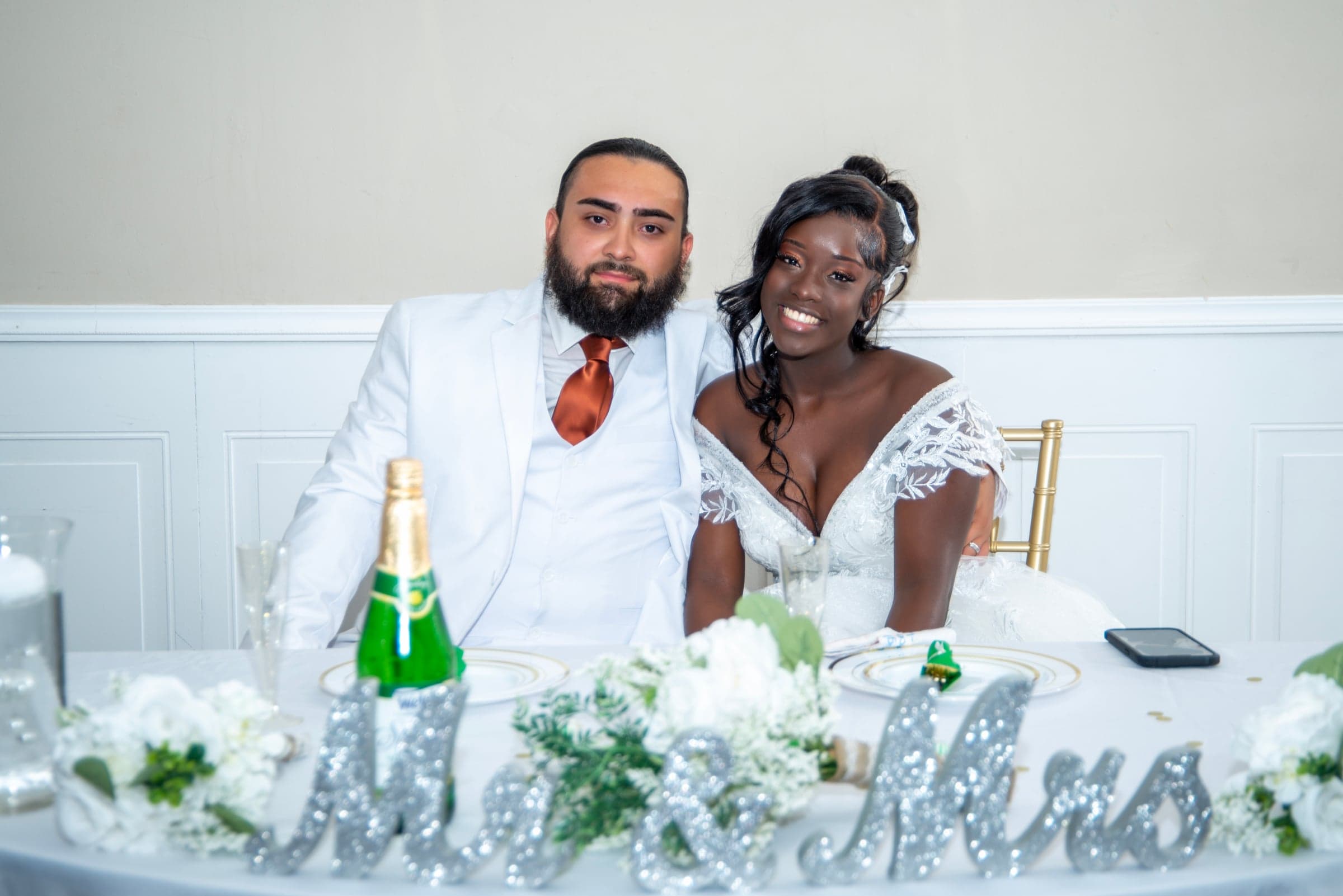 Newlyweds at sweetheart table, wedding reception