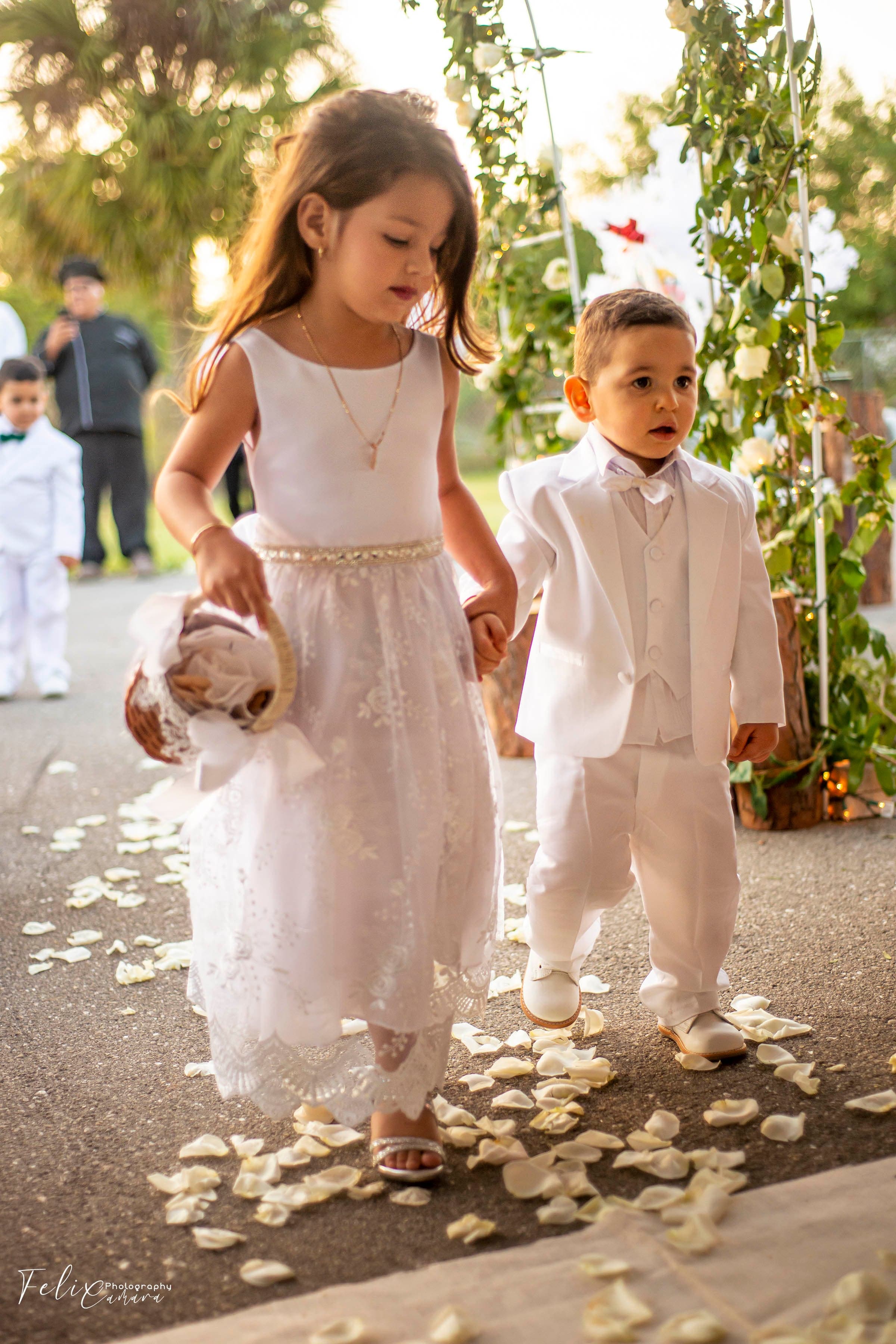 Flower girl and ring bearer walking down aisle, wedding ceremony