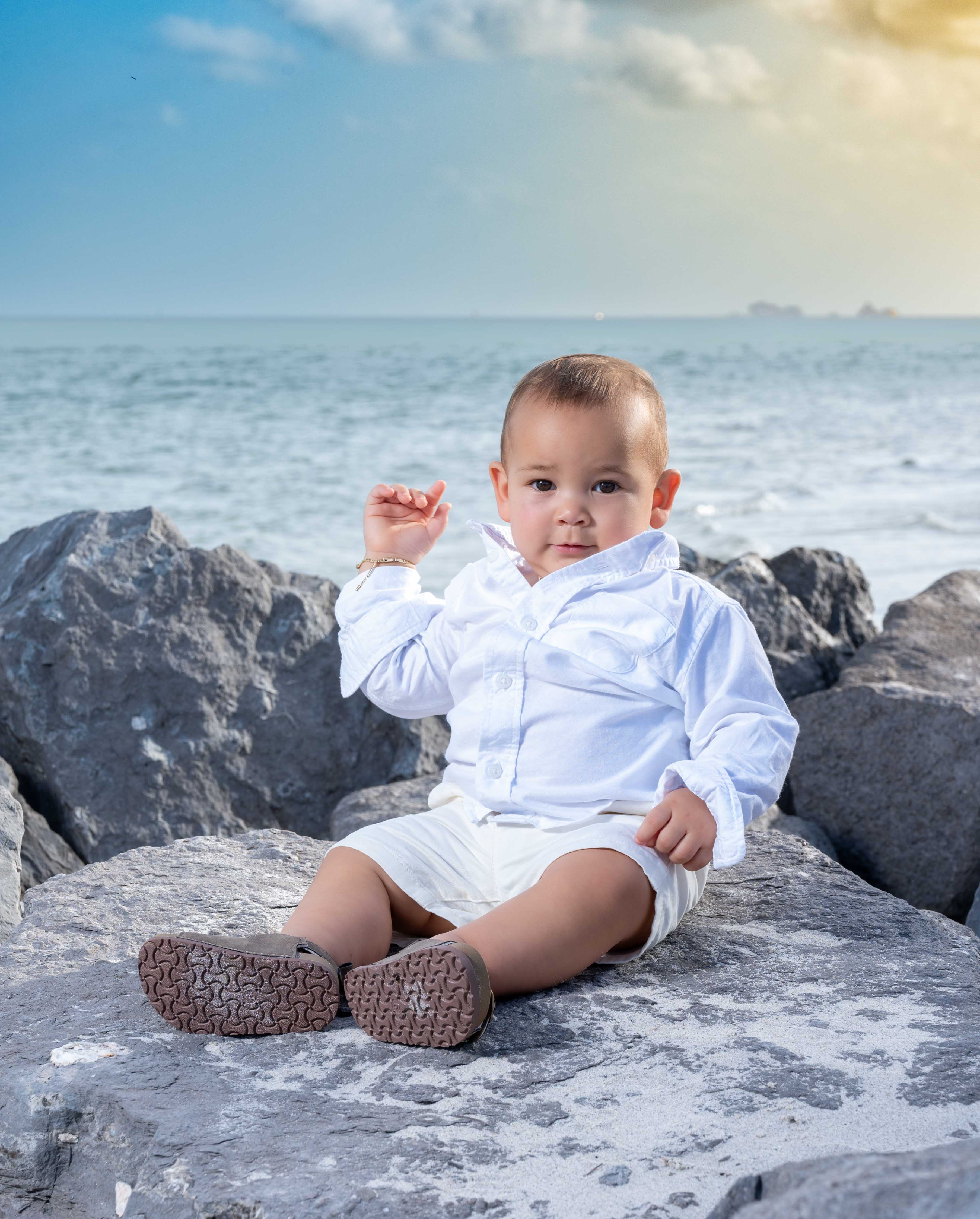 Toddler portrait beside a tree trunk