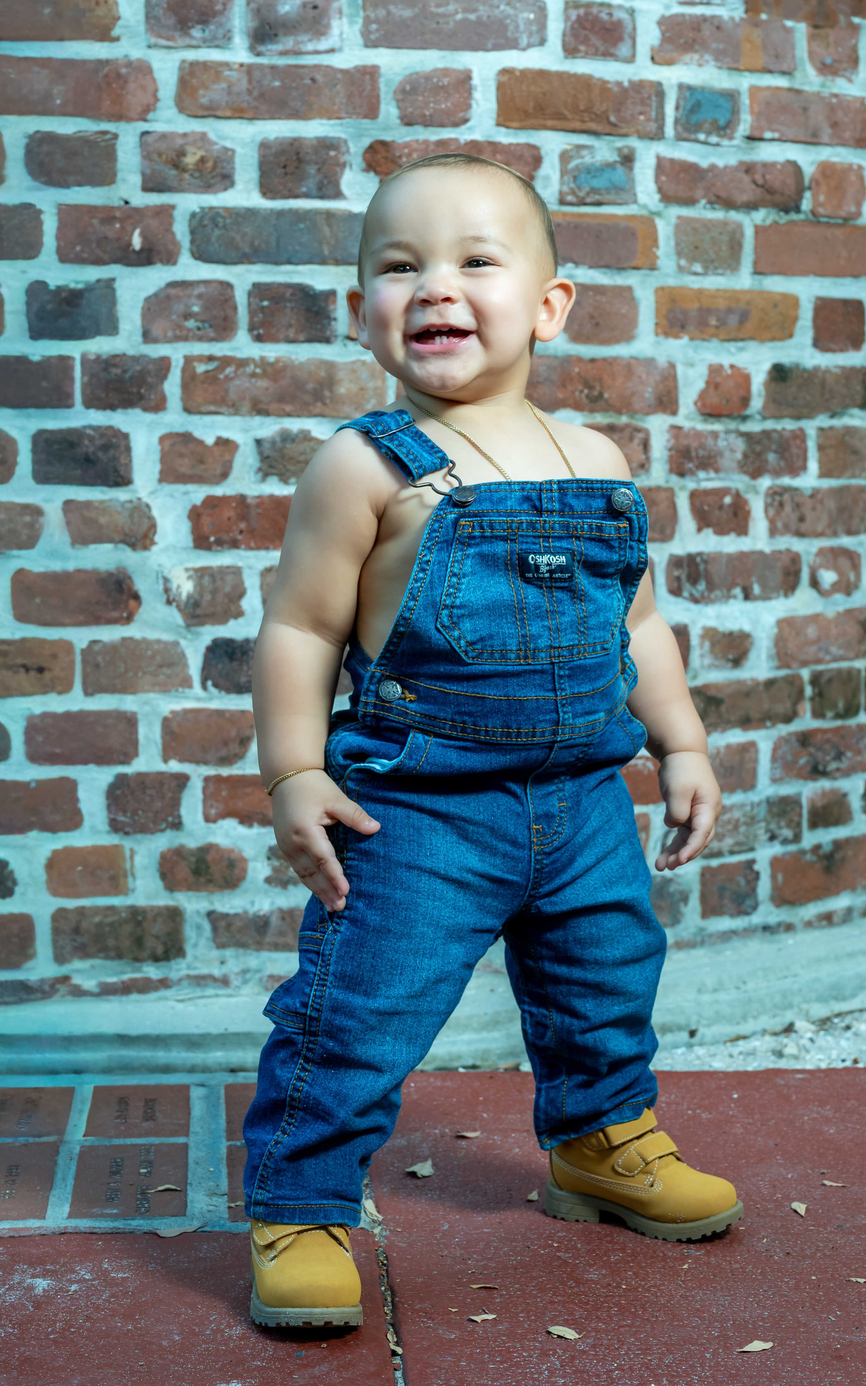 Baby portrait against a brick wall backdrop