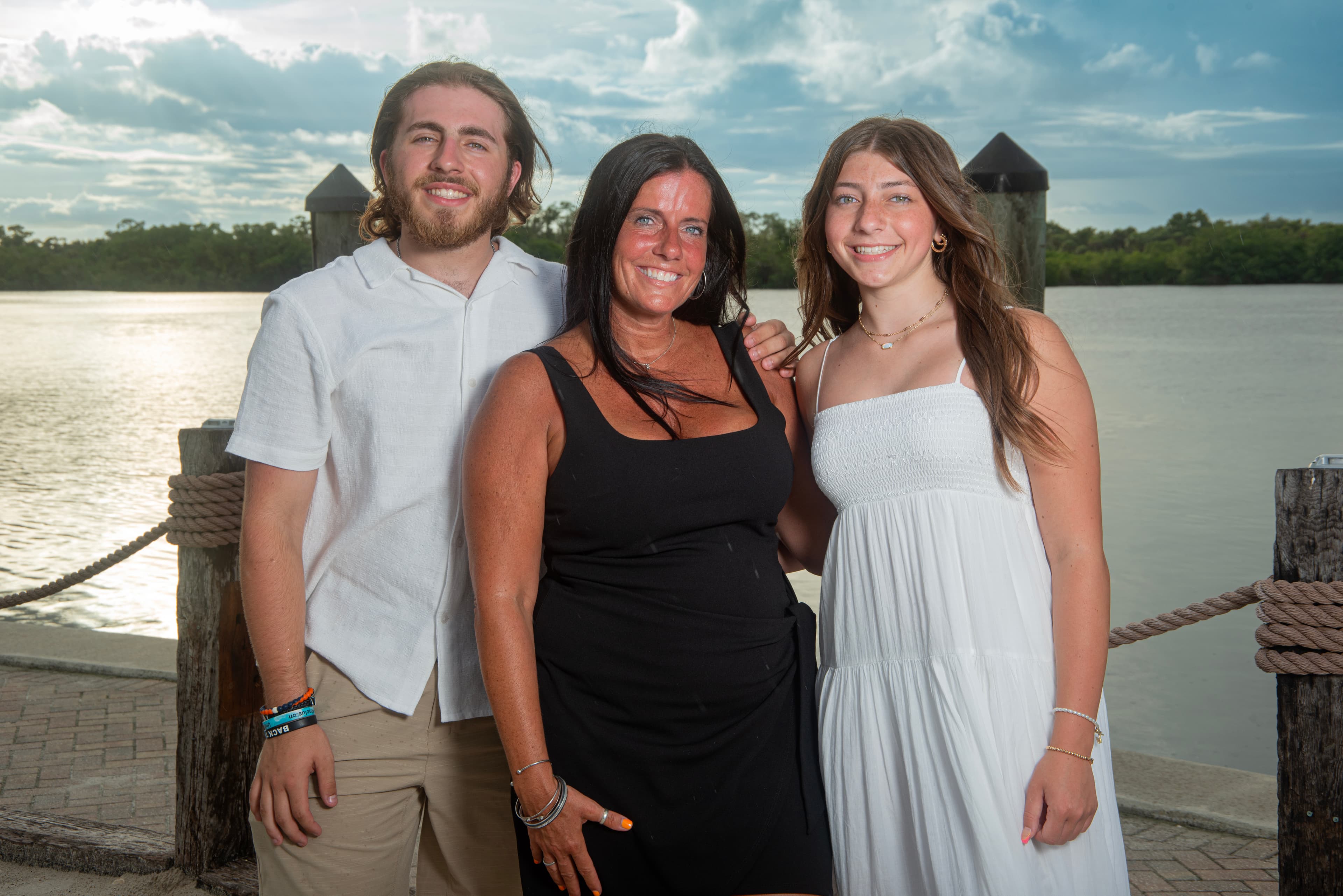 Mother and two teens portrait on the waterfront dock