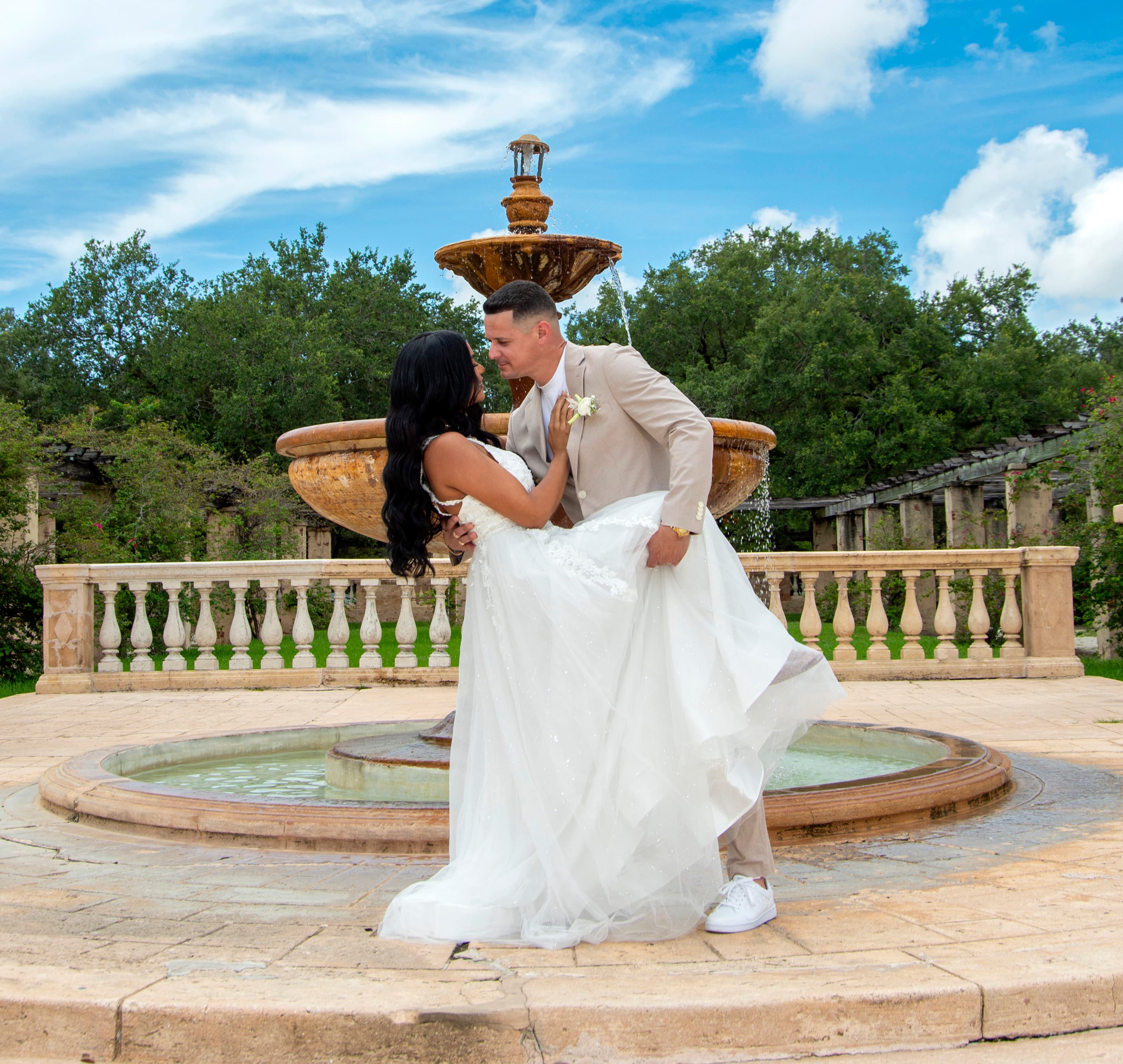 Groom portrait leaning against a stone column